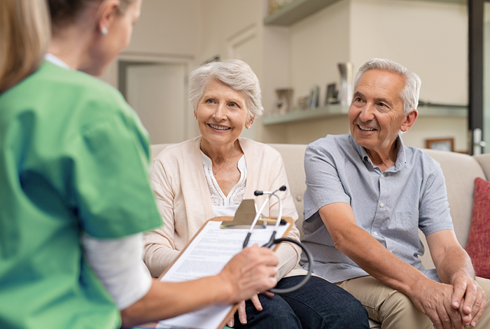 Pflegerin erklärt älterem Ehepaar die Pflegegrade